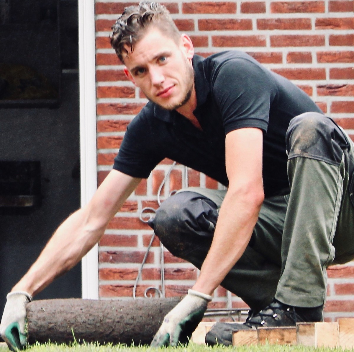 Hovenier legt graszoden in een tuin